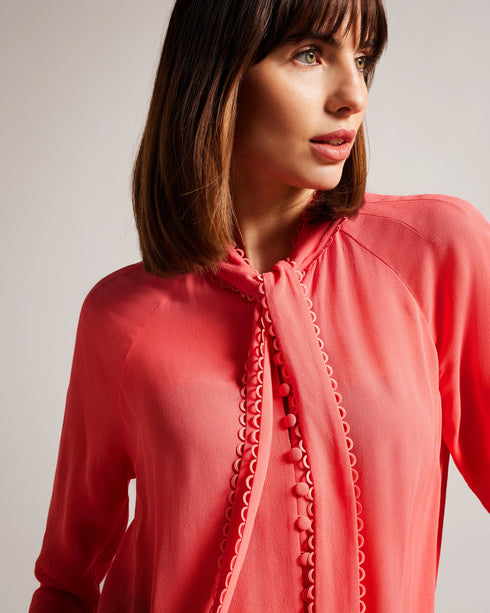 JULINAA-Tops-JULINAA is a lightweight, feminine layer that transitions easily from day to evening. This lightweight blouse pairs wonderfully with wide-leg trousers and heels for a polished office look—or switch it up for jeans and sandals on a sunny weekend getaway. Blouse Neck tie Looped rouleaux trim Long sleeved Button fastening Lightweight fabric Julia is 5'10" / 1.78m and wears Coral in a Ted size 1- Ted Baker Romania
